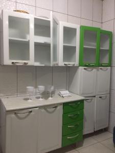 帕尔马斯HOSTEL D´ SALLES (PRÓXIMO AO AEROPORTO)的厨房配有绿色和白色的橱柜和冰箱。