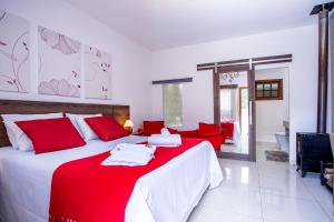 蒙特韦尔迪Pousada das Videiras的一间卧室配有一张带红色枕头的大床