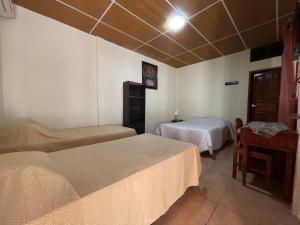 马塔加尔帕Hotel Vizcaino的酒店客房设有两张床和一张桌子。