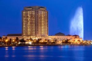 吉达吉达丽思卡尔顿酒店 的一座大建筑,晚上靠近水体