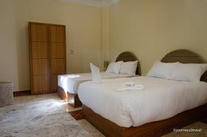 开罗Golf Pyramids View的一间卧室配有两张床和白色毛巾。