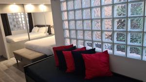 卡普戴尔DAJO的客房配有一张床铺和一张带红色枕头的桌子。