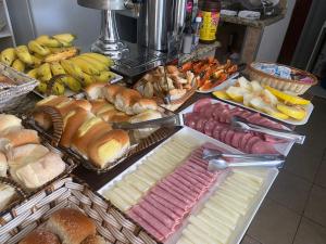 阿帕雷西达Maranata Hotel的一张桌子,上面放着许多不同类型的面包和糕点