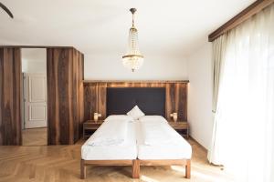 卡尔达罗Romantik Hotel Jagdhof的一间卧室配有一张床和一个吊灯
