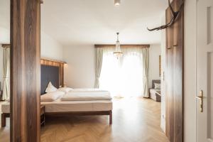 卡尔达罗Romantik Hotel Jagdhof的一间卧室设有一张床和一个大窗户