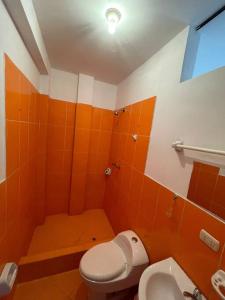 HuantaYachanapaq Wasi II的橙色浴室设有卫生间和水槽