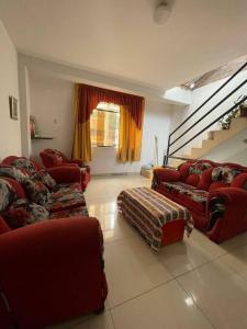 HuantaYachanapaq Wasi III的一间带红色沙发的客厅和楼梯