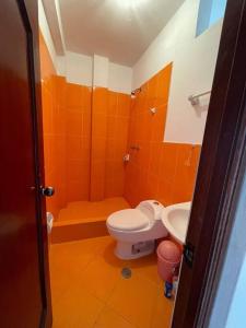 HuantaYachanapaq Wasi III的橙色浴室设有卫生间和水槽