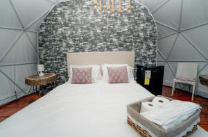 巴拉奥纳省圣克鲁斯Ovalulú Glamping Hotel的砖墙客房内的一张大床