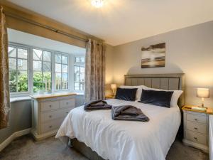 科夫堡3 Bed in Corfe Castle 81369的一间卧室配有一张带白色床单和窗户的床。
