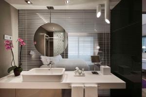 马德里马德里欧式建筑NH精选酒店的一间带水槽和镜子的浴室