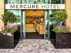 纽波特Mercure Newport的一座盛有紫色花卉的合并酒店前方的商店