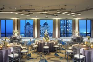 亚特兰大The Starling Atlanta Midtown, Curio Collection by Hilton的一个带桌椅的宴会厅和大窗户