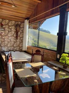 维奥康德马奥Pousada Rancho da Montanha的客房设有浴缸、桌子和窗户。