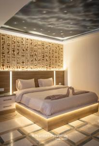 开罗Narmer Pyramids View的一间卧室配有一张大床和木制床头板