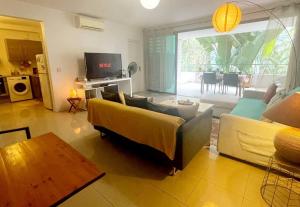 普纳奥亚E KOMO MAI的客厅配有黄色沙发和电视