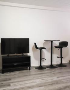 蒙特利尔Cozy studio apartment - 240的客厅配有2张凳子和1台平面电视