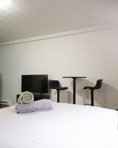 蒙特利尔Cozy studio apartment - 240的一间卧室配有一张带两把椅子的床和一台平面电视。