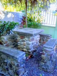 Calibishiecome and enjoy singing birds的花园里的石墙和两个石凳
