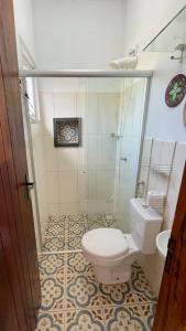 卡兰卡斯Chalé Arcos do Sol - Carrancas的一间带卫生间和玻璃淋浴间的浴室