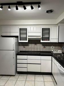 多伦多Premium home with Garden view, private parking的厨房配有白色橱柜和白色冰箱。