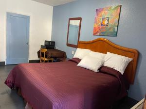 奥克兰Laurel Inn的一间卧室配有一张带红色毯子和镜子的床