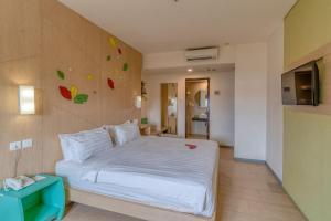 玛琅Ascent Hotel & Cafe Malang的卧室配有白色的墙壁床