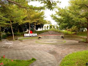 BatusangkarEmersia Hotel & Resort Batusangkar的带有长椅和标志的公园
