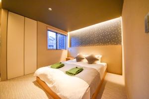 奈良Hotel Rokune的一间卧室配有一张大床,上面有绿毛巾