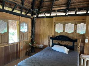 Playa Punta ArenaPunta Arena EcoHostal & EcoFit的卧室配有一张床铺,位于带木墙的房间内