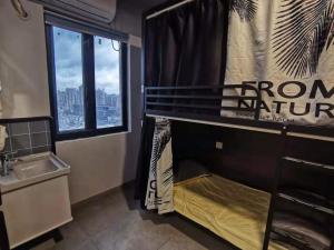 杭州杭州Yootel油条精品青年社交旅舍的浴室设有双层床、水槽和窗户