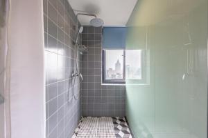杭州杭州Yootel油条精品青年社交旅舍的带淋浴的浴室和玻璃门