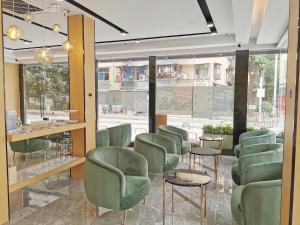 深圳广纳酒店（深圳福田店）的一个带绿色椅子的沙龙和候机室