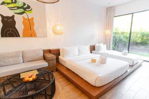 爱妮岛Nacpan Beach Resort的一间带两张床和一张沙发的客厅