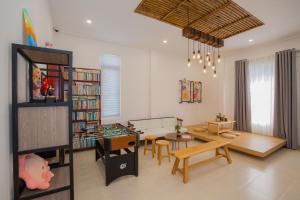 大叻Suri Homestay的客厅配有桌子和书架