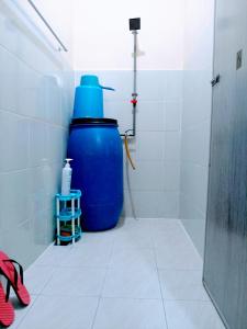 山打根ILHAM HOMESTAY Taman Sejati Mile 7的浴室的角落里有一个大蓝色的桶