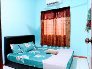 山打根ILHAM HOMESTAY Taman Sejati Mile 7的一间卧室设有一张床和一个窗口