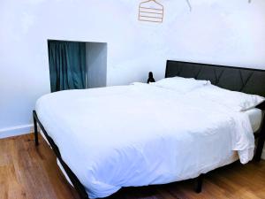 塔拉哈西One room in a renovated duplex house near FSU的卧室铺有木地板,配有一张大白色床。