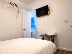 塔拉哈西One room in a renovated duplex house near FSU的卧室配有一张床和壁挂式平面电视。