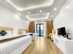 河内Chemi Noi Bai Airport Hotel的酒店客房设有两张床和一台平面电视。