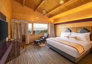 KīarjüSTa Cliffend Resort & Spa, Mashobra的一间卧室配有一张床、一张书桌和一台电视