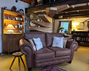纽波特Ty-Newydd Cottage的客厅里一张棕色的皮沙发