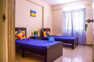 贾夫纳Nallur Mylooran Arangam的客房设有两张带紫色床单的床和窗户。