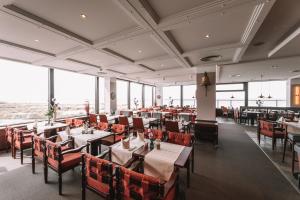 瓦尔内明德海王星酒店的用餐室设有桌椅和窗户。