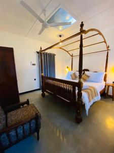高尔Happy Valley Residence Unawatuna的一间卧室配有四柱床和椅子
