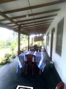 锡吉里亚Sigiriya Hillside View Villa的凉亭下带桌椅的天井
