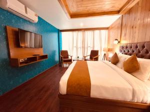马拉里TATA Vista Resort Mall Road Manali - Centrally Heated & Air Cooled的酒店客房,配有床和电视