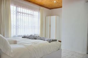科克斯塔德Lake Acres Guest House的一间卧室设有一张床和一个大窗户