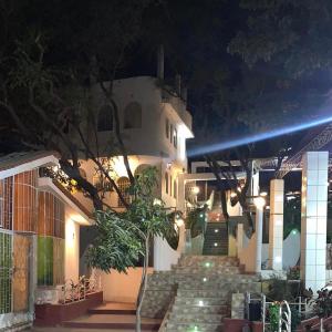 伊察Casa de Campo - Fundo Raquel的一座晚上有楼梯和灯光的建筑