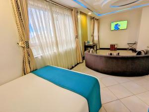 内罗毕梅丽丽酒店的带浴缸和桌子的客房
